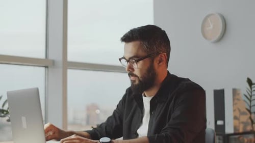 Young Bearded Businessman Working on Laptop in Office