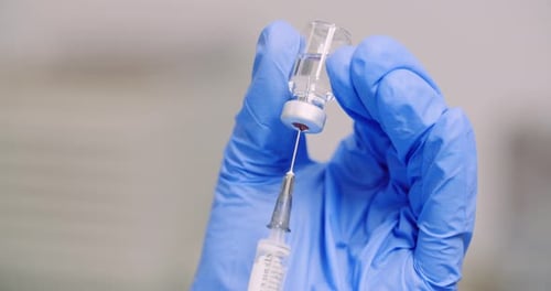 Doctor Filling Syringe with Vaccine, Preparing for Injection. COVID-19