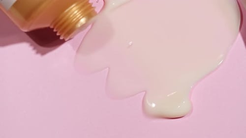 Cosmetic Cream Being Spread on Pink Background