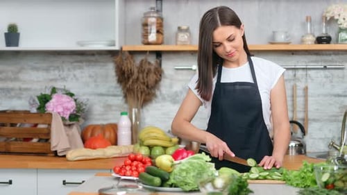 Woman Slicing Vegetables in a Bright Kitchen
