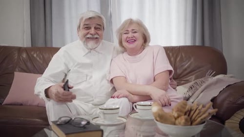 Senior Couple Relaxing Together at Home Watching TV
