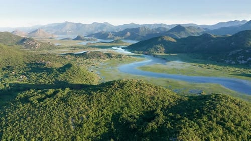 River meandering through the valley toward distant mountains, in the morning