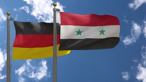 Germany and Syria Flags Waving Against Blue Sky