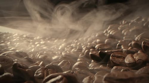 Macro Shot Rösten von Kaffeebohnen in einem dunklen Schlüssel gefilmt Der Rauch, der aus dem Rösten von