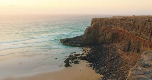 Beautiful Landscape with Sandstone Rocky Cliffs Over the Sea Surface at Sunset Golden Hour