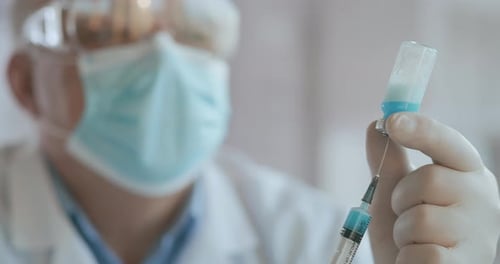 Doctor Draws Vaccine To Syringe, Vial, Covid-19, Coronavirus Ampoule, Injection. Close Up Shot of