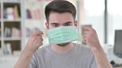 Young Adult Putting On a Protective Face Mask