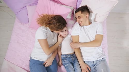 Loving Family Relaxing Together on Bed at Home