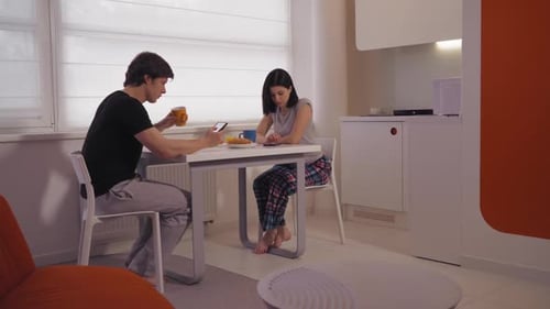 Couple Relaxing Together at Table with Phones