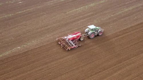 Traktor bei der Arbeit im Feld. Traktor mit einer modernen Sämaschine auf einem neu gepflügten Feld