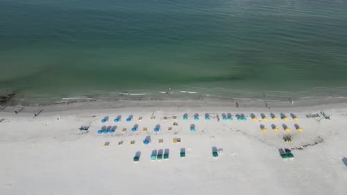 Flying over beach resort beach chairs and continuing into the ocean. The camera shows the transition