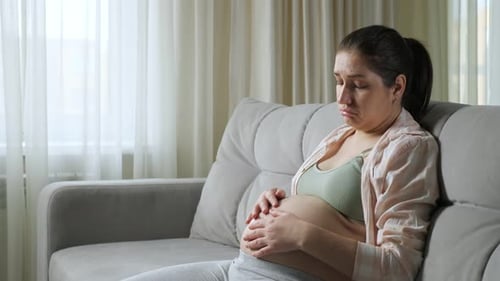 Pregnant Woman Resting on Couch at Home