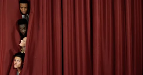 Actors peeping from curtain