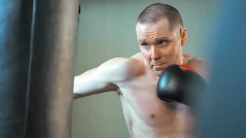 Young Caucasian Muscular Sportsman Boxing in Gym