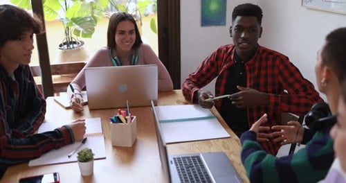 Multiracial students studying together inside library