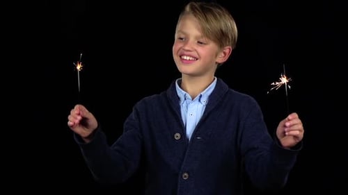Happy Boy with Sparklers on Black Background