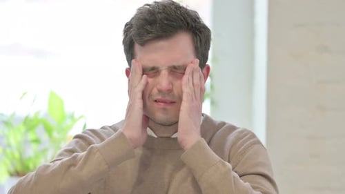 Man Rubbing Temples due to Pain or Headache