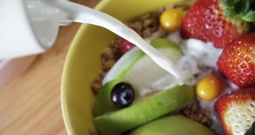 Milk Being Poured Over Fruit and Cereal