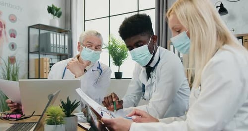 Doctors Collaborating in Medical Office During Pandemic