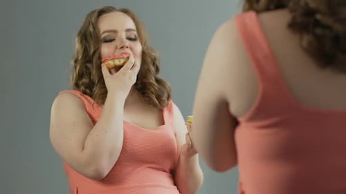 Woman Enjoys Eating Donuts in Front of Mirror
