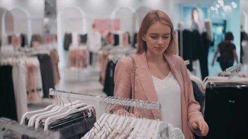 Junge Frau beim Einkaufen von Kleidung im Geschäft