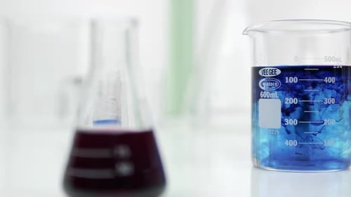 Panning view of beakers with different color liquid in them