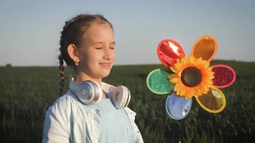 Happy Girl Holding Wind Toy in Green Field, Rejoicing Life