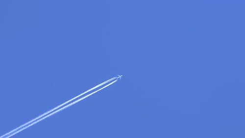 Airplane Flying Through Clear Blue Sky