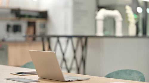 Young Adult Man Sits Down at Laptop