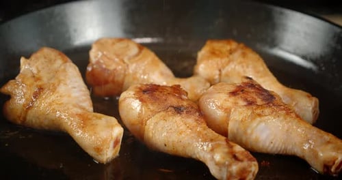 The Pan with Fried Chicken Drumsticks Slowly Rotates.