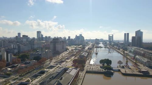 Aerial view passing over a wateway revealing Paseo del bajo highway at Buenos Aires city. Dolly left