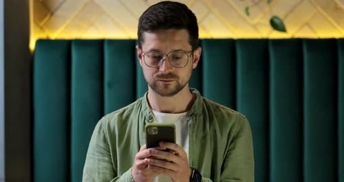 Man Uses Phone in Urban Environment Close Up