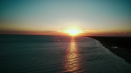 Sunset Over the Sea Waves Wash the Sandy Beach