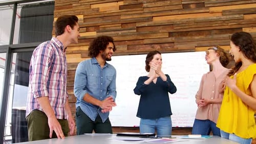 Business executives giving high fives while working in office