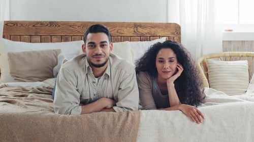 Smiling Couple Lying Together on Bed