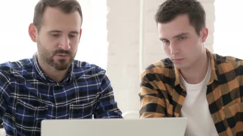Two Men Collaborating on a Laptop in Office