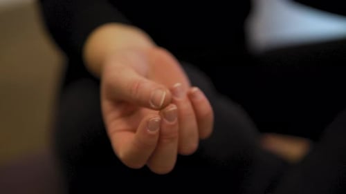 Closeup shot of female yoga instructor's hand in her fitness studio. Meditation and relaxation conce