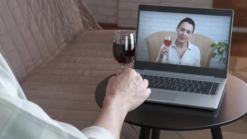 People Video Chatting with Wine on Laptop