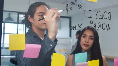 Professionals Brainstorming Ideas on Glass Wall