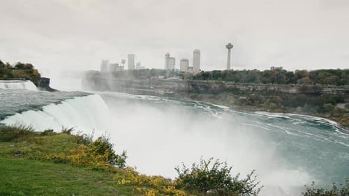 Pan Shot La poderosa corriente de agua de las Cataratas del Niágara en la distancia que puedes ver la costa canadiense