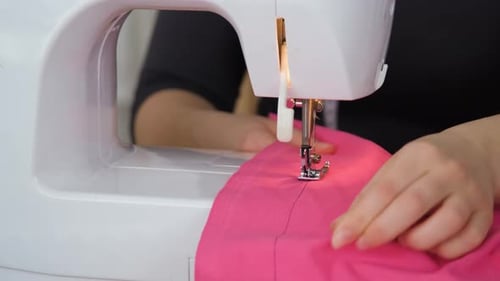 Woman Sewing Pink Fabric with Sewing Machine