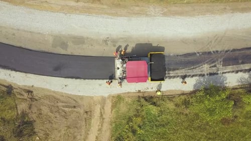 Luftaufnahme des Straßenneubaus mit Arbeitern und Asphaltbaumaschinen bei der Arbeit