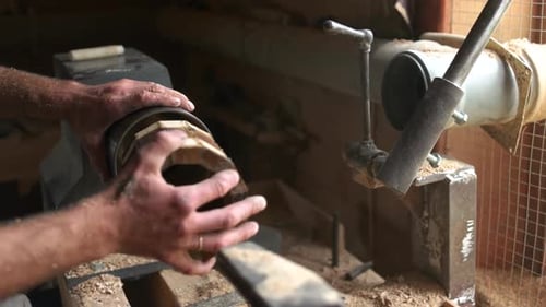 Woodworker Placing Wood on Lathe with Hammer