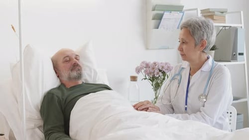 Female Doctor Holding Hand of Male Patient in Hospital