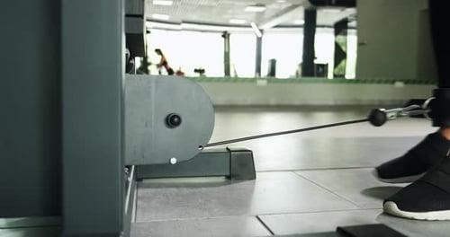 Starke hübsche Frau trainiert Muskeln im Sportsimulator im Sport Club. Sportlerin beim Sport