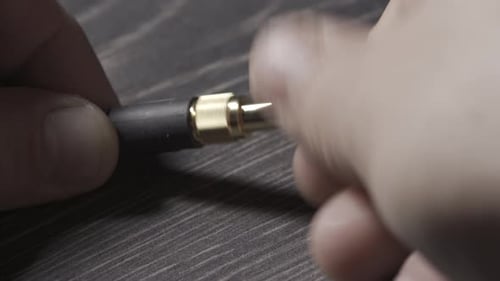 Audio Jack Being Manipulated by Hands on Wood