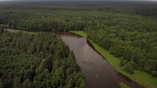 View From the Top of a Group of Tourists on Kayaks Floating Along a Turbid River