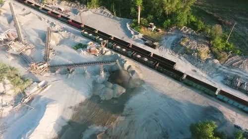 Aerial of transportation carriages loaded with minerals from granite quarry