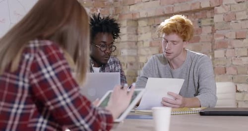 Group of Young Multiethnic Colleagues Sitting in Office and Discussing Project. Portrait of