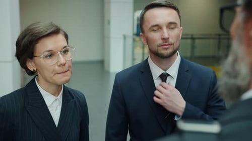 Cheerful Office Workers Men and Woman Talking in Lobby Smiling Wearing Suits